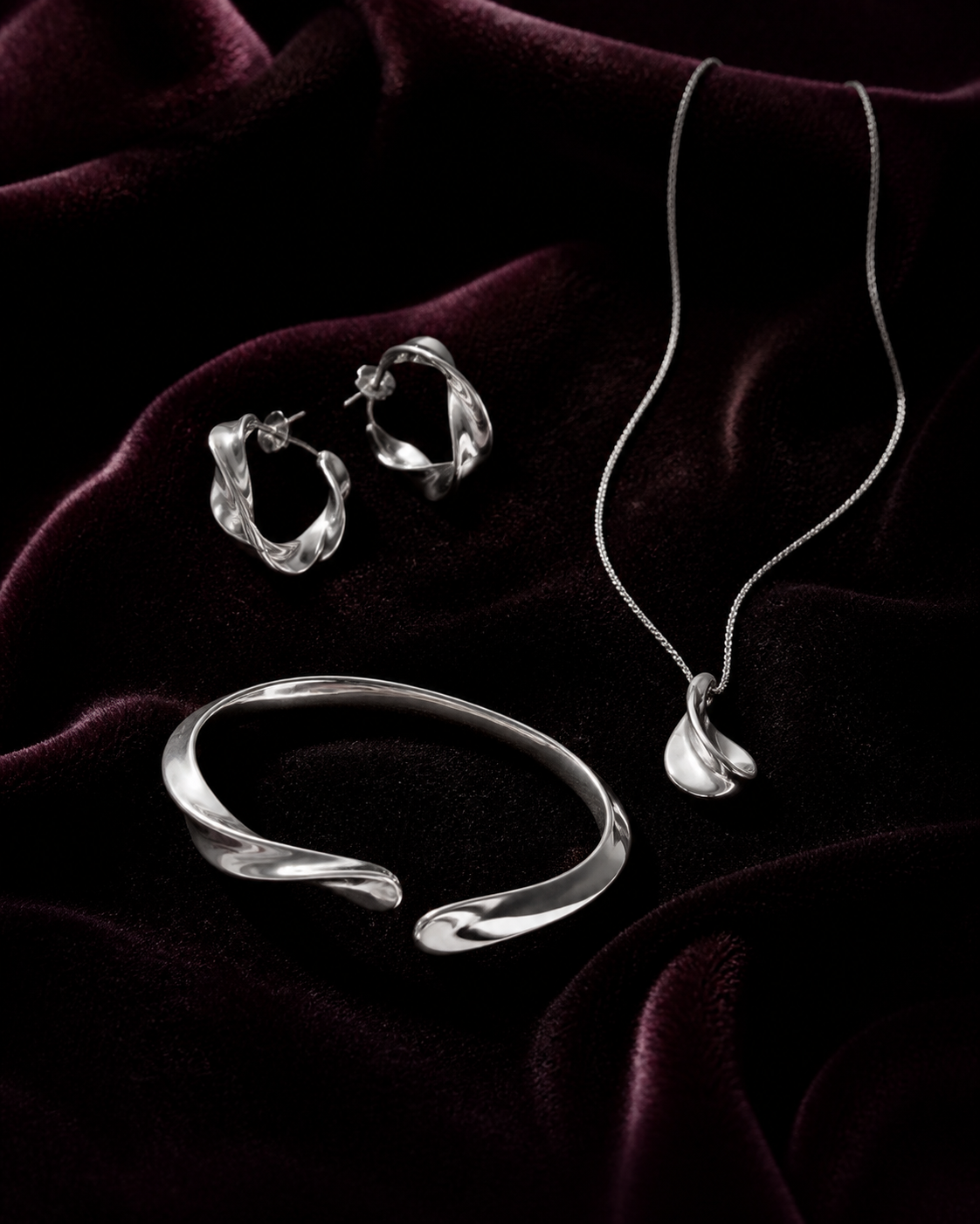 Silver earrings, necklace and bracelet on velvet